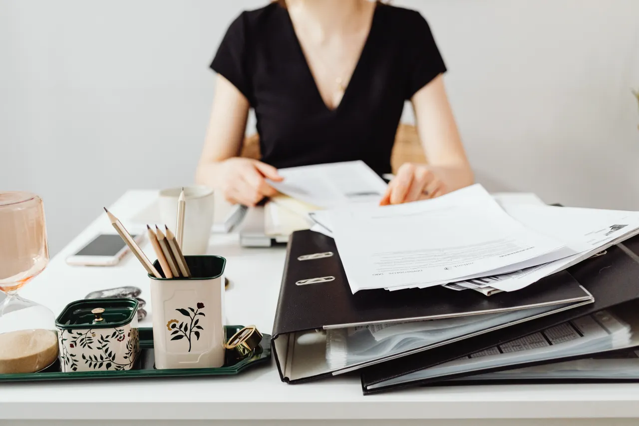 Desk with binders, documents and office supplies