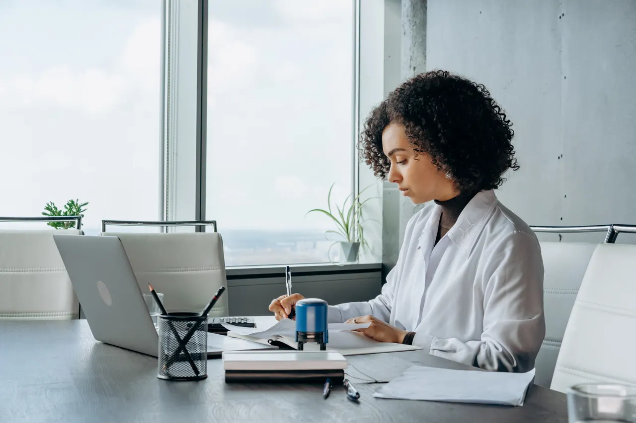 Professional working on a laptop in a bright, modern office