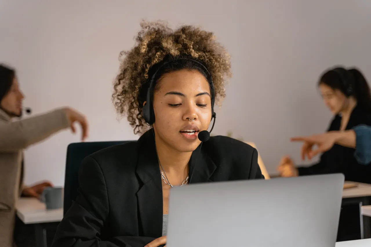 Support agent wearing a headset working on a laptop